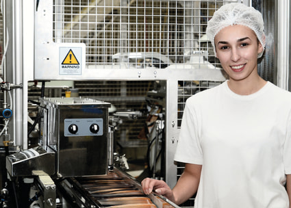 Junge Mitarbeiterin in der Produktion Junge Mitarbeiterin in der Produktion